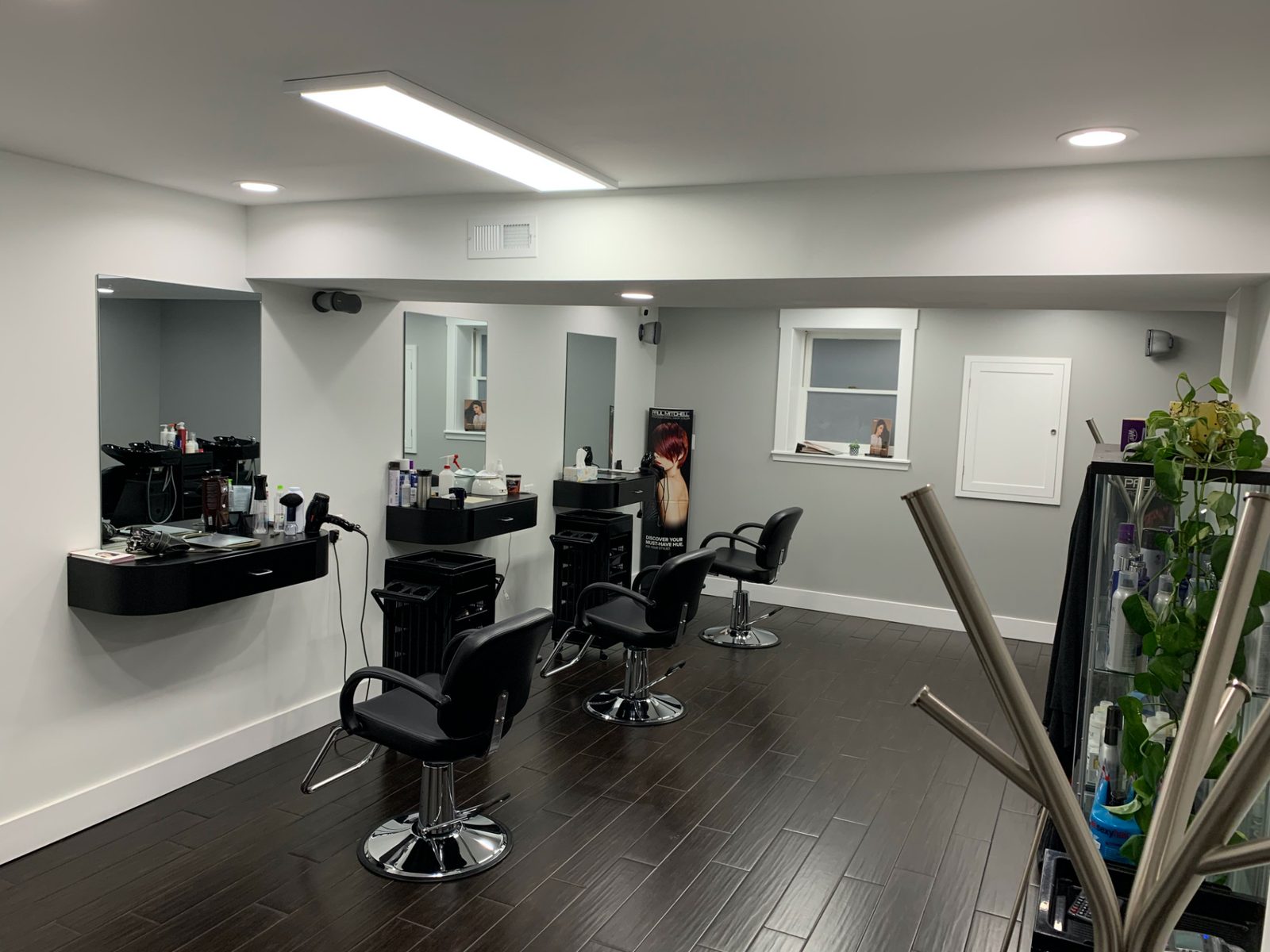 Inside Edwin's Hair Style: styling chairs, mirrors and product shelves in a bright salon